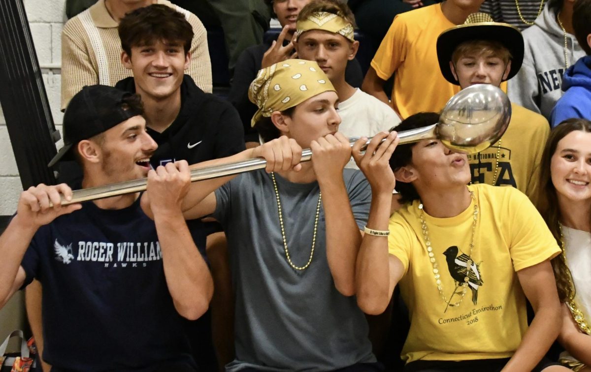 Nonnewaug seniors, from left, Jeff Bernardi and Thomas Lengyel, hold the spoon as Liam Sandor pretends to drink during the fall sports pep rally Sept. 19. The spoon is a longtime symbol of pride in Nonnewaug athletics.