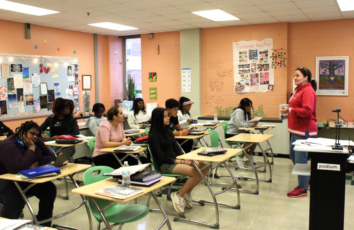 A diverse group of students with immigrant backgrounds listen to English teacher Emily Graham's class instructions.