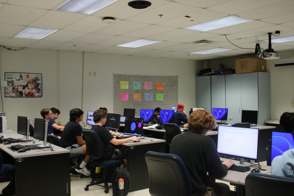 Students watch a video about phone scams on a SMART Board while working on a project about online scams and identity theft during the fourth hour cybersecurity class on Friday, Sept. 13. Chief Information Officer Bob Deneau said suspicious links are often the root cause of large cyberthreats.