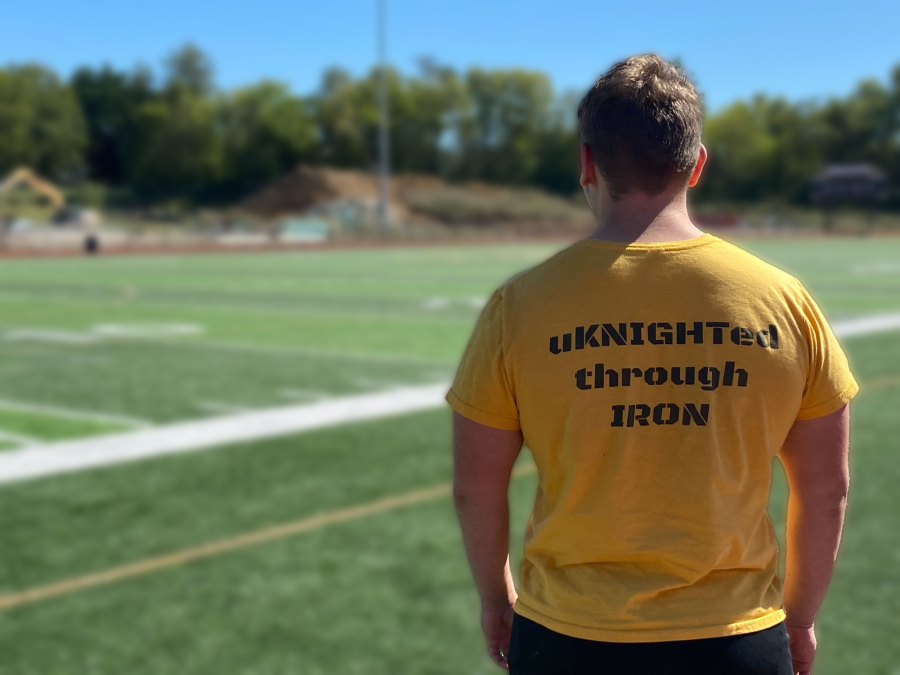 Junior Tatem Chrismer reps a “uKNIGHTed Through IRON” t-shirt as he walks onto the football field.