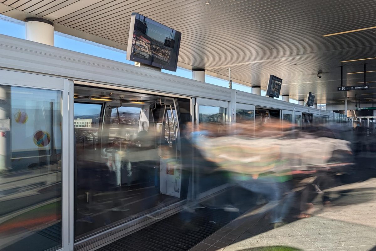 A long exposure photo of people getting off an Oakland Airport Connector train at Coliseum Station in Oakland, Calif. on Monday, Oct. 14, 2024. (Neal Wong / Golden Gate Xpress)