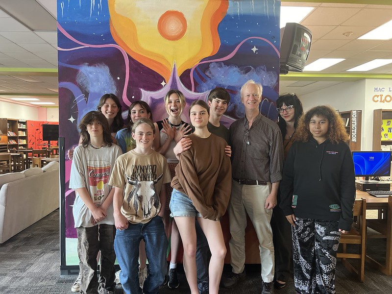 Paul Pew beams with students next to mural dedicated to him. At the end of the school year last year, students and faculty decided that they needed to dedicate something to him for his career at McCallum. According to Pew, the thing he will miss most about teaching here is the students, and teachers. “I worked with amazing, kind, and talented people at both ends of the building, math and music,” Pew said. “I was lucky enough to have Ms. Seckar as a department head and all the math teachers as friends. 