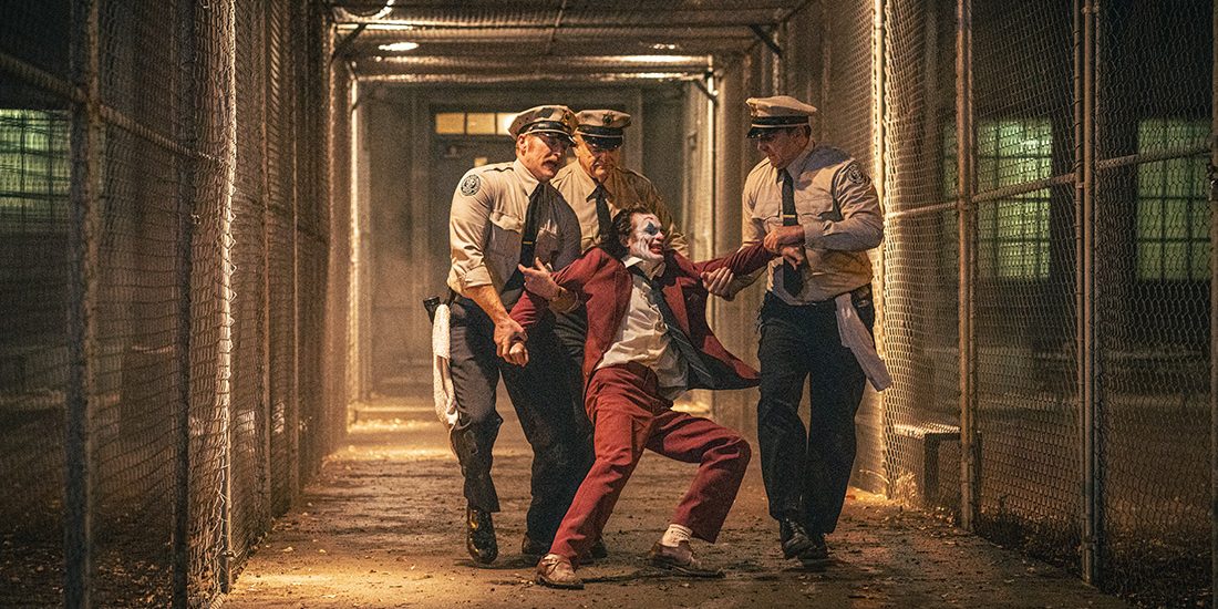 Arthur Fleck (Joaquin Phoenix) resists the abusive guards at Arkham Asylum in Joker: Folie a Deux. Unfortunately, this picture also represents how many audience members felt after watching this disjointed and off-putting movie, as judging from the overwhelming critical, audience, and fan reactions coming out of the film's opening weekend.