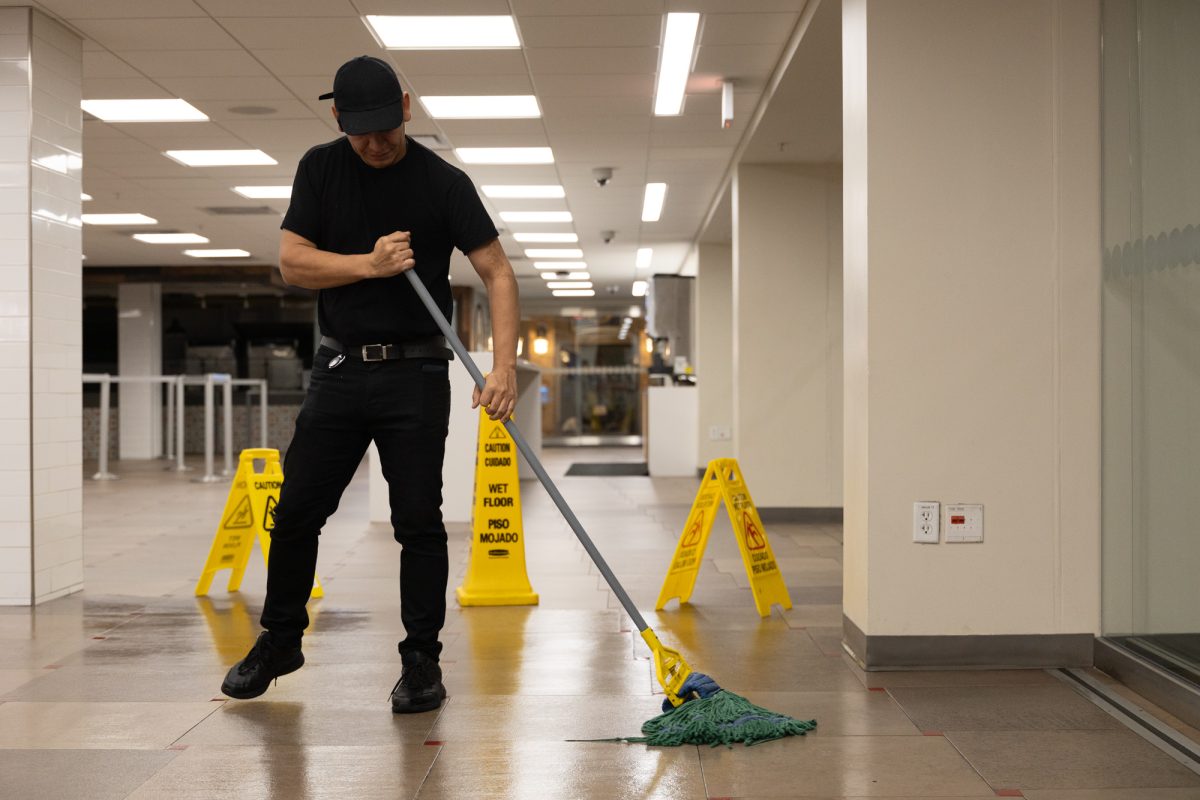 A custodial worker cleans the floors at the Memorial Student Center Chick-Fil-A on Wednesday, Nov. 20, 2023. (Chris Swann/The Battalion)