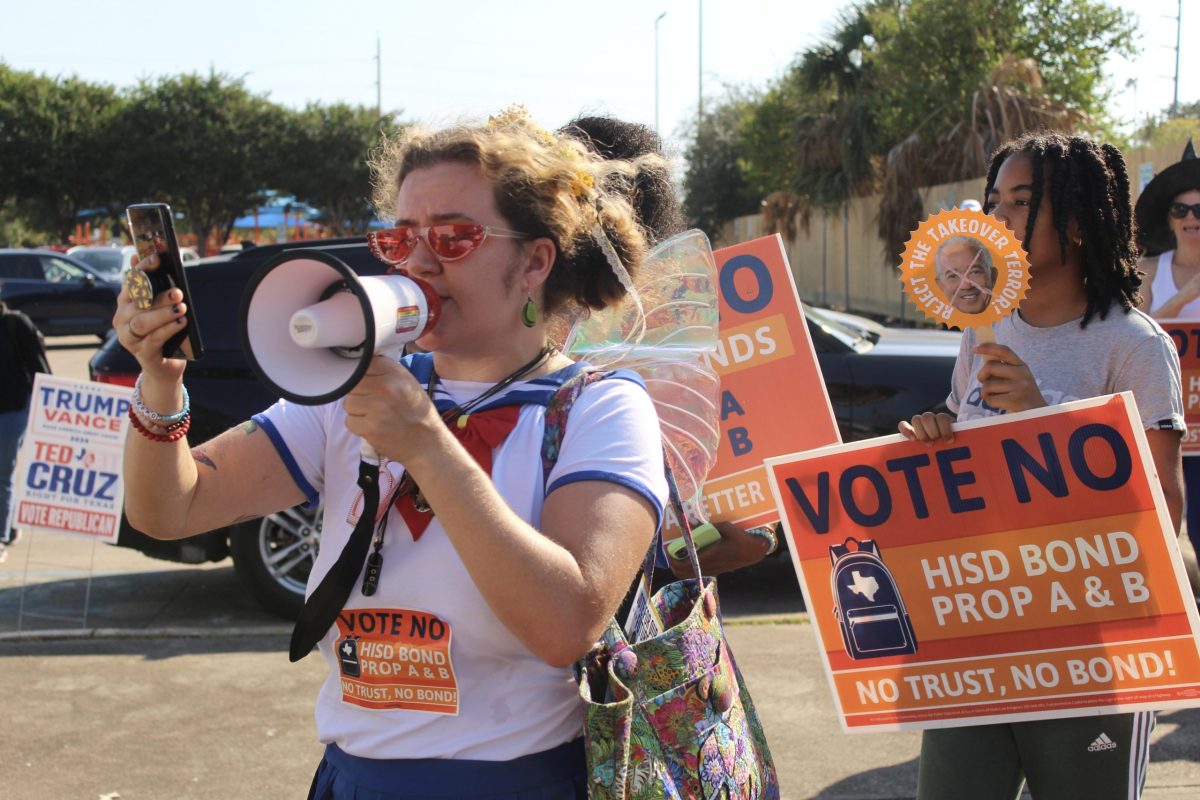 About 20 opponents to the HISD bond gathered at the Community Voices for Public Education's Halloween-themed "Haunt the Polls" event to encourage voters to vote against the bond. Attendees marched in the parking lot of the Metropolitan Multi-Service Center chanting call-and-response protests.