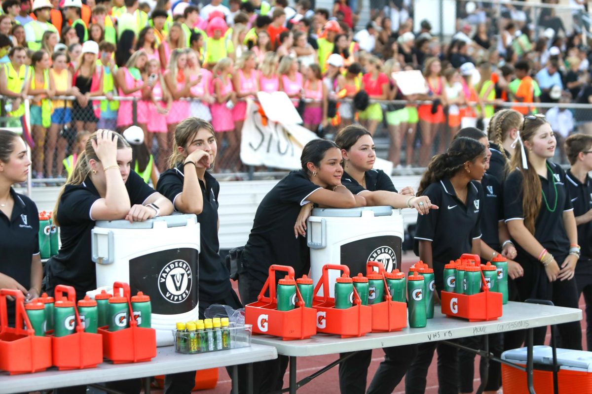 During the varsity football game, Bella Angus and Nicole Pearle wait to assist the trainers.