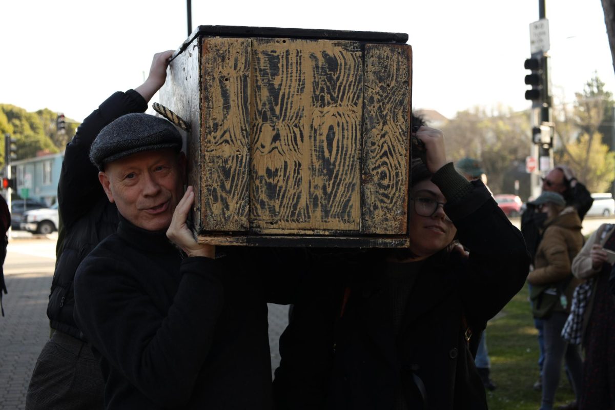 People carry a casket on their shoulders during the funeral march-styled protest against layoffs and budget cuts on Wednesday, Dec. 11, 2024. (Gabriel Carver / Golden Gate Xpress) 