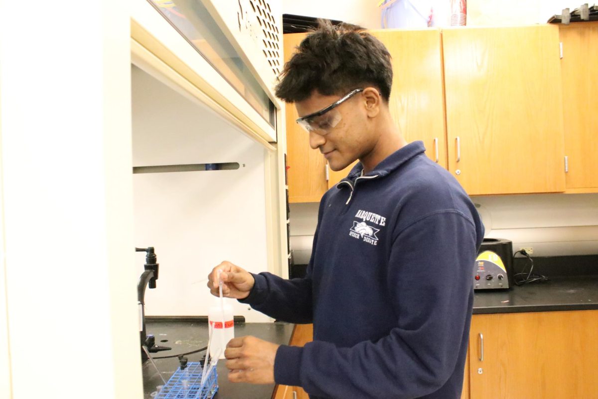 Ethan George, junior, works under a fume hood in the science lab. George represented Missouri at the Global Youth Institute where he learned about food security, agriculture and sustainability. 