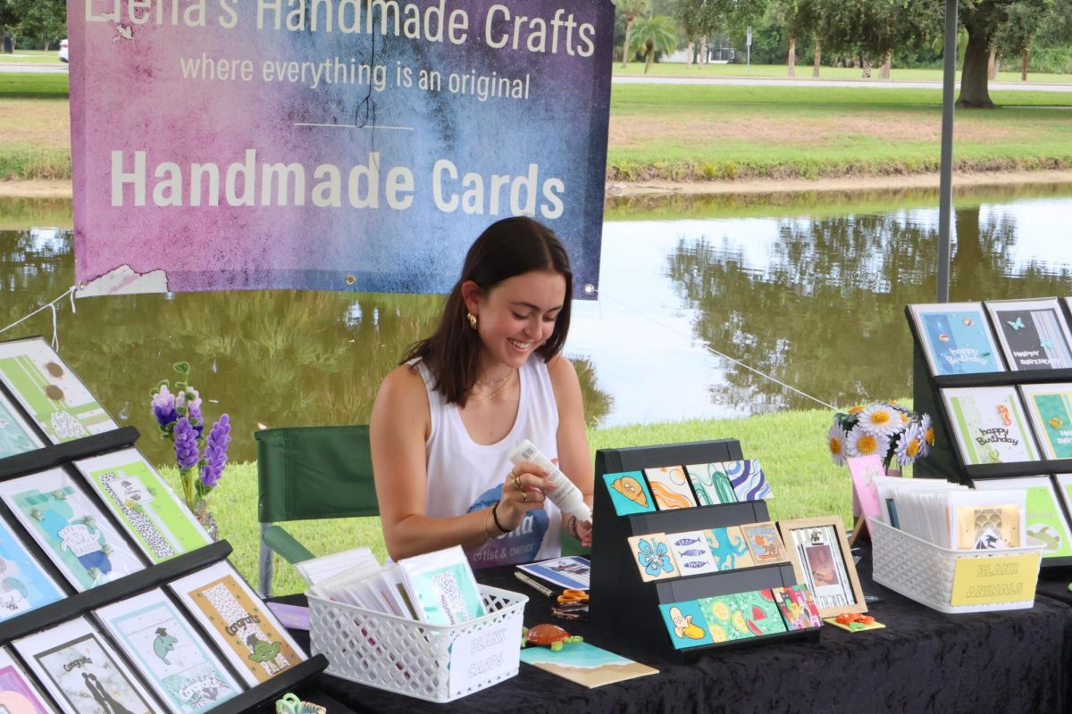 Senior Elena Weeks prepares specialized handmade cards for sale at the Viera East Woodside Farmers Market on Sept. 14.