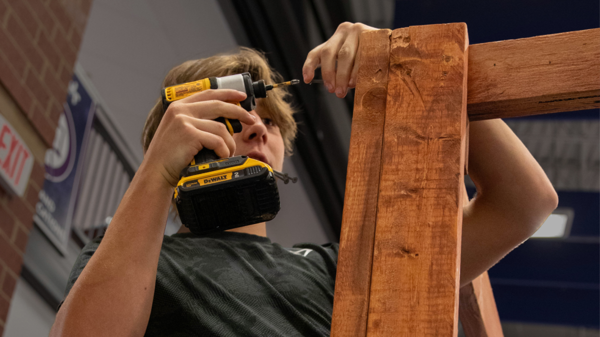 Student, Nathan Mohr (12) drills and helps sturdy up the Perch.