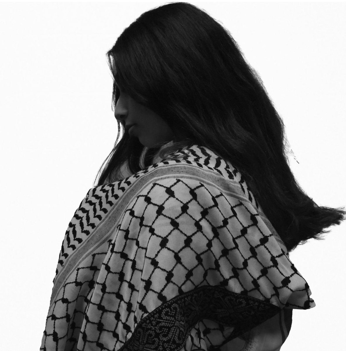 A girl grips onto a keffiyeh. The keffiyeh is often cited as a sign of resistance of the Palestinian people.