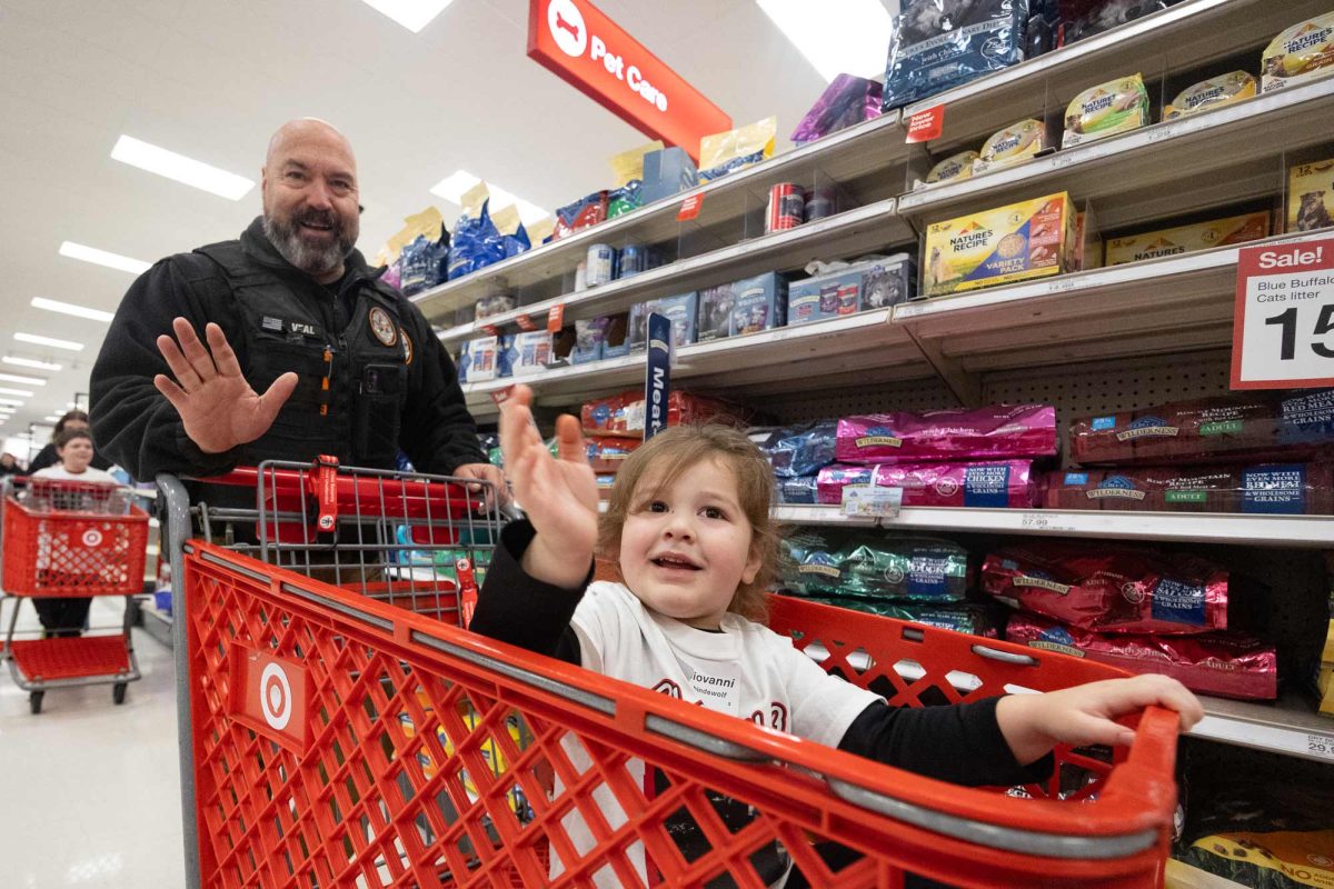 TISD Police Officer Bart Veal and one of his four shoppers roll through Target to the store’s toy aisle while at the Shop with a Cop & Firefighter event on Dec. 3, 2024. Veal and other first responders from around the Texarkana area helped provide children with Christmas presents.