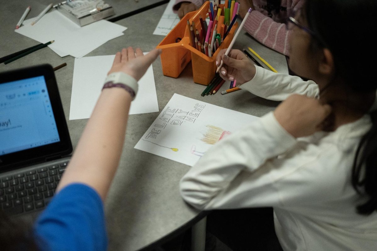 Lower school students in extended day design pages of the student-run publication The Late Day News.