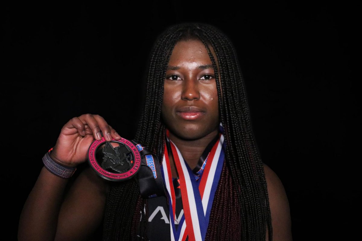 Girls wrestling captain Annalisa Afrifa holds a second place medal she won at the state championship meet her sophomore year. She wears medals she won at individual competitions. “It feels amazing to win,” Annalisa said. “It tells [me] that all my hard work hasn’t gone to waste.” 