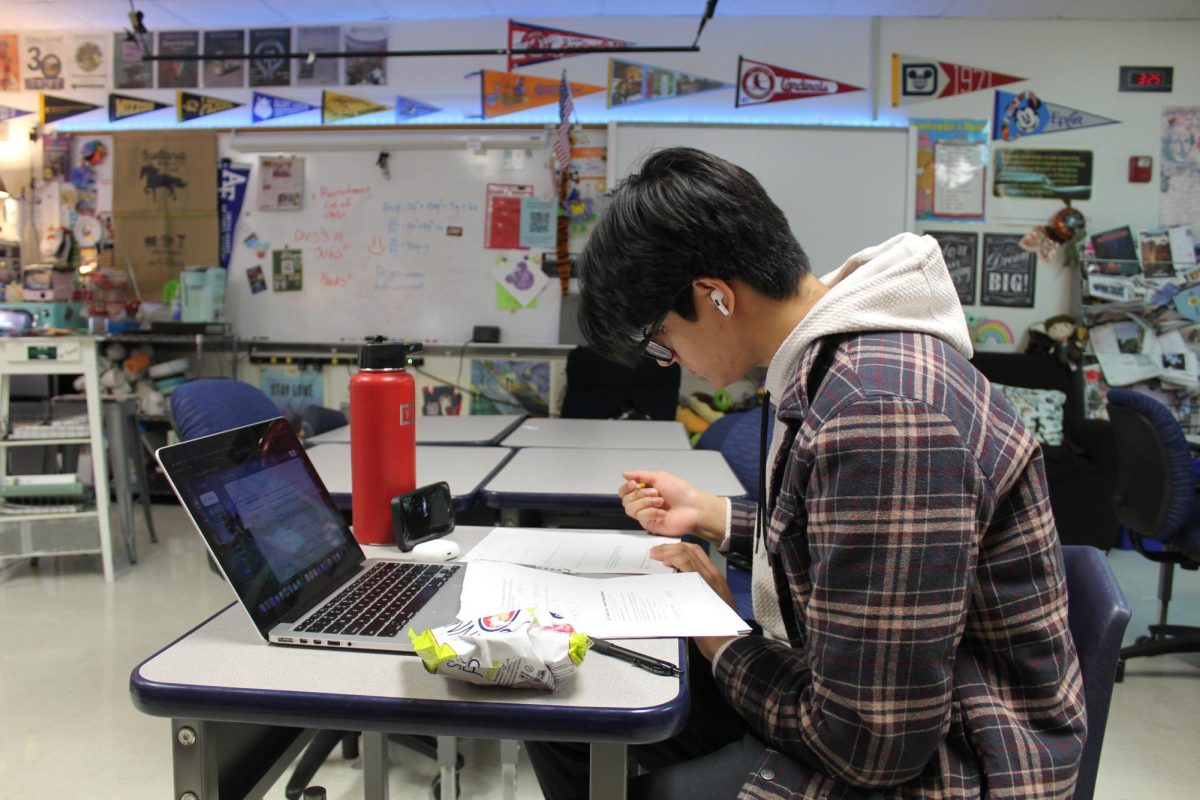 Mehul Mushuni, junior, works on his AP Calculus AB homework while watching a TV show. Students often multitask in an attempt to reach peak productivity, but experts question the effectiveness of this habit.