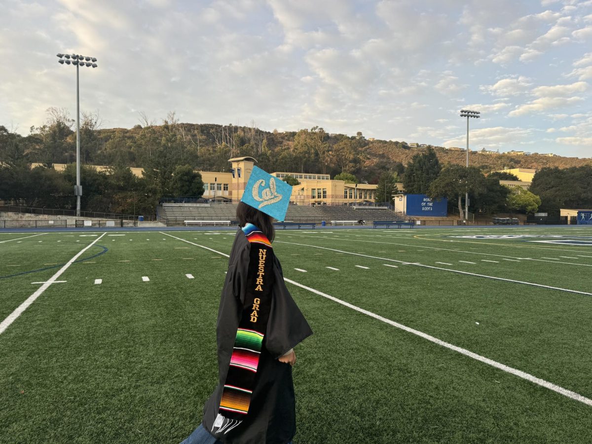 A latina student proudly graduates high school with a sarapa sash hung around her neck as a representation of a her culture. The importance of working hard and gaining an education are core values within the Latino community.