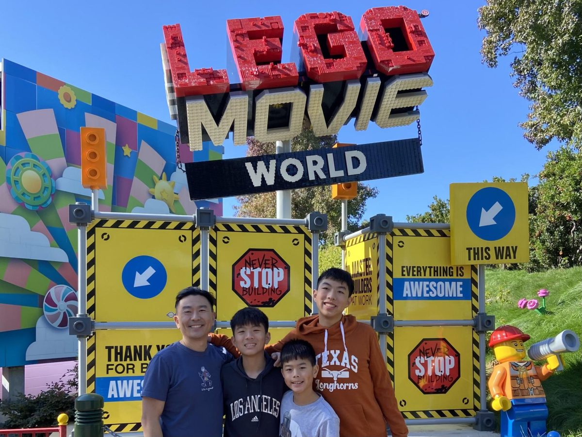 Senior Jayden Peng and his family pose for a picture in front of a LEGO Movie World sign. Photo by Eunice Peng | Used with permission