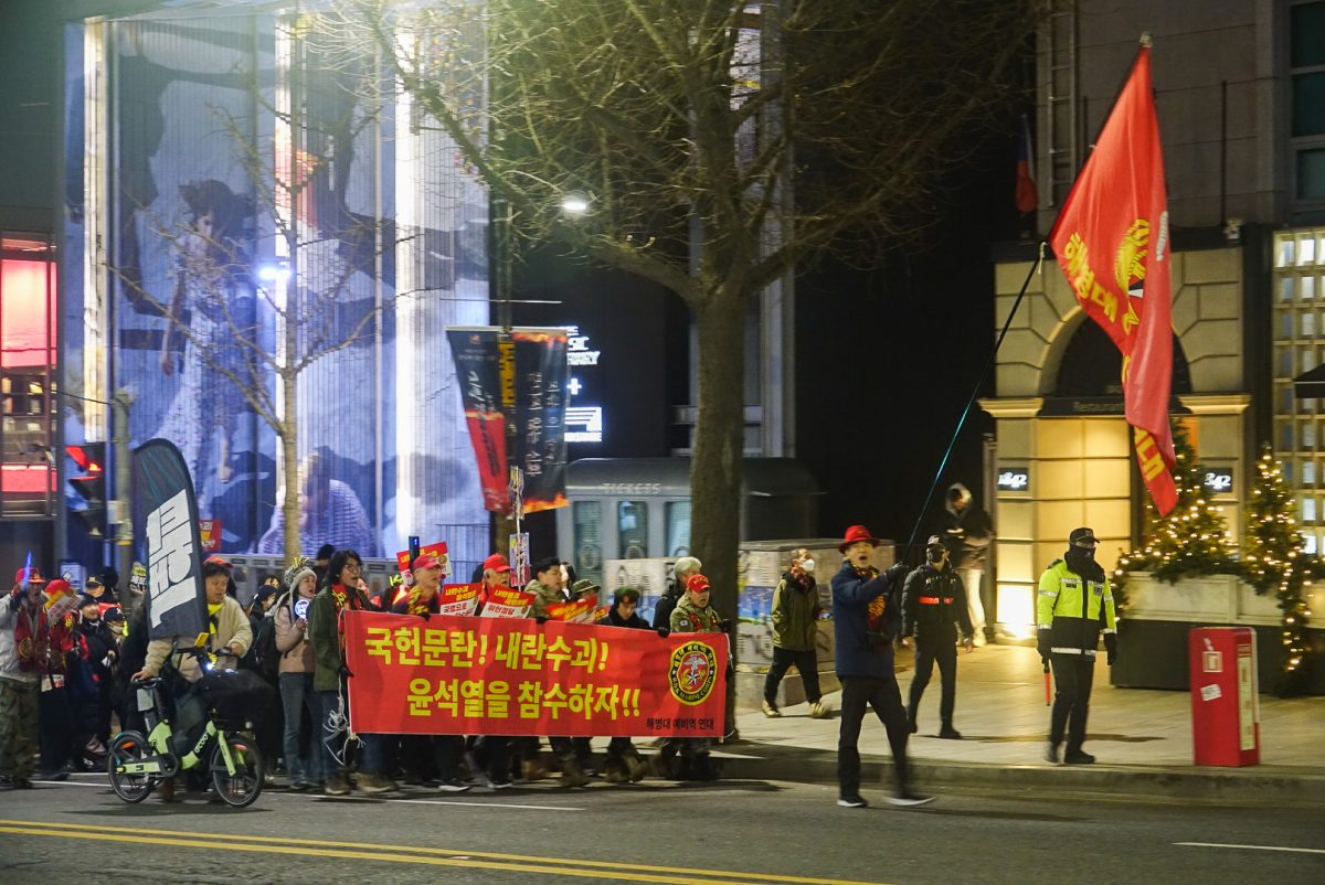 Protesters carry red banners, saying “National Assembly Disorder! Civil War Leader! Behead President Yoon!” in Itaewon, South Korea on Jan. 4. Photo | Samuel Teo