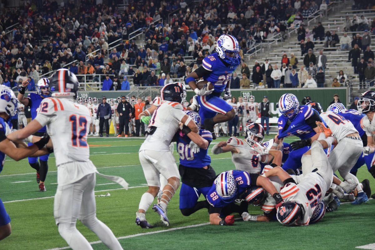 Freshman Elijah Cromwell (26) jumps over players into end zone during the football state champion game on Dec. 7, 2024. Creeks football team was one of 5 teams to win state championships in the fall season. 