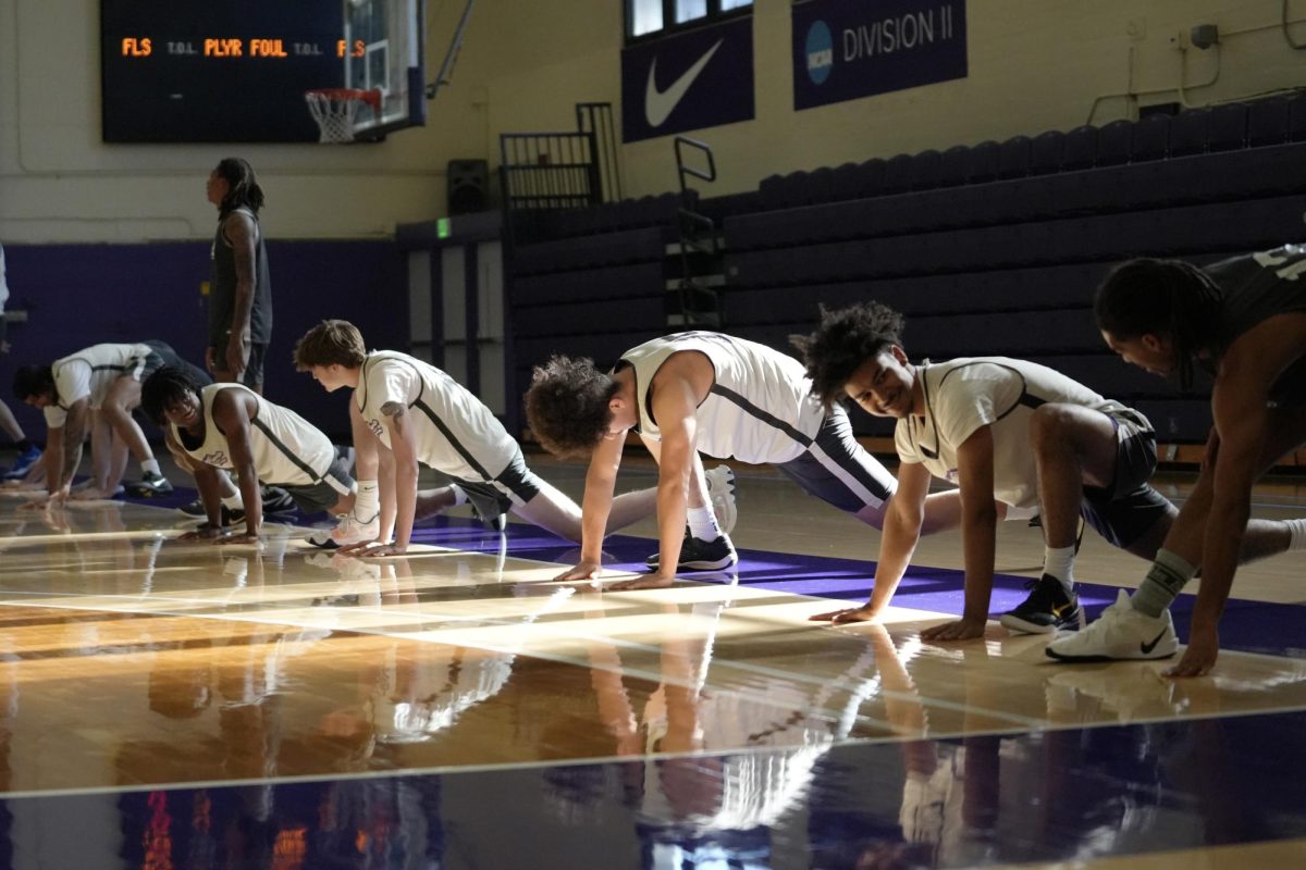 Players on the San Francisco State University men’s basketball team stretch before the team’s practice on Wednesday, Dec. 4, 2024. (Andrew Fogel / Golden Gate Xpress)