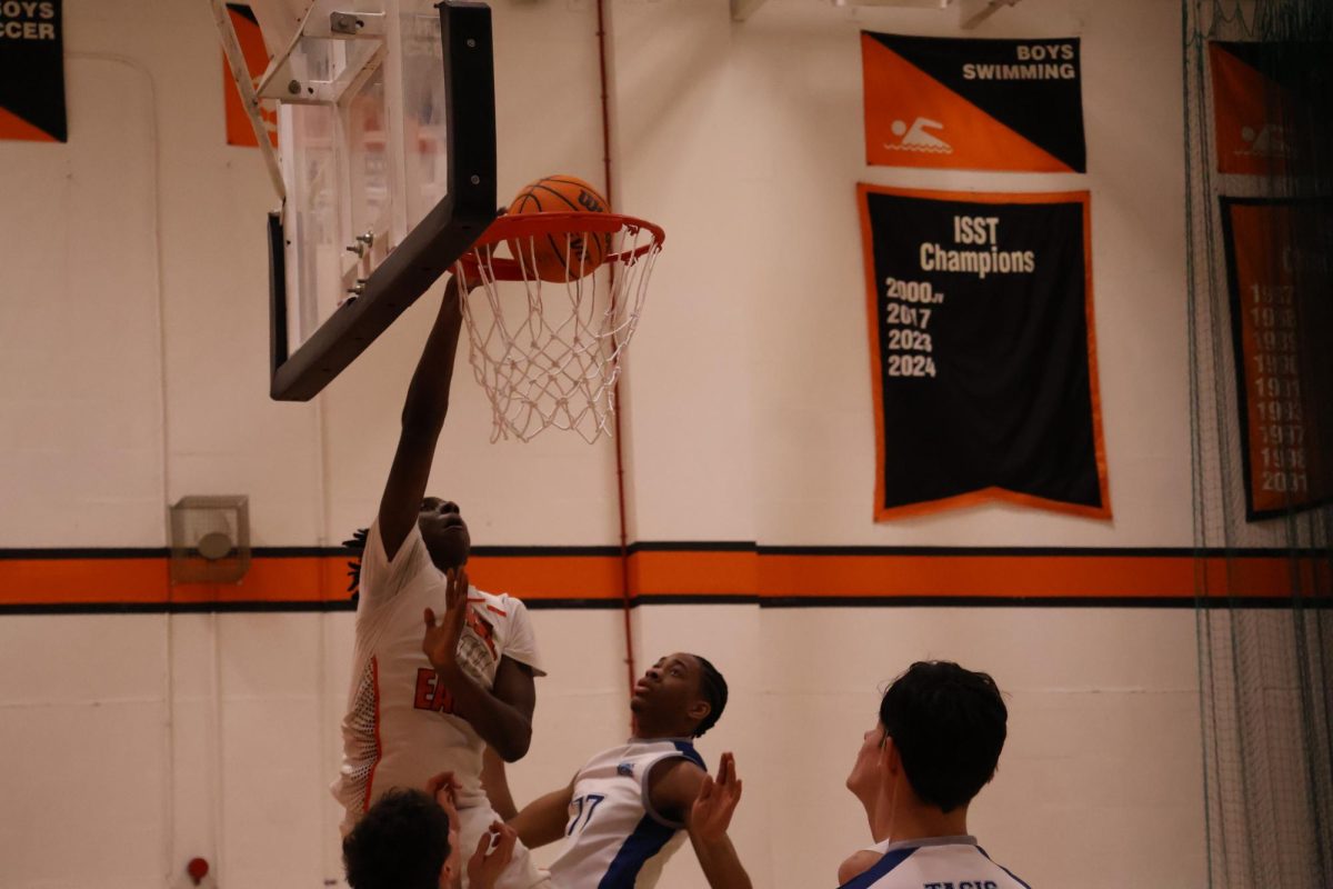 Jelani Conteh (’26) leaps toward the hoop as he extends his arm to dunk Feb. 5. Member of the boys varsity basketball team Jack Duffy (’25) said the team’s collaboration helped them succeed. “The game was really well played for all of us,” Duffy said. “We really came together, showed a lot of chemistry and were able to, you know, get the victory.”