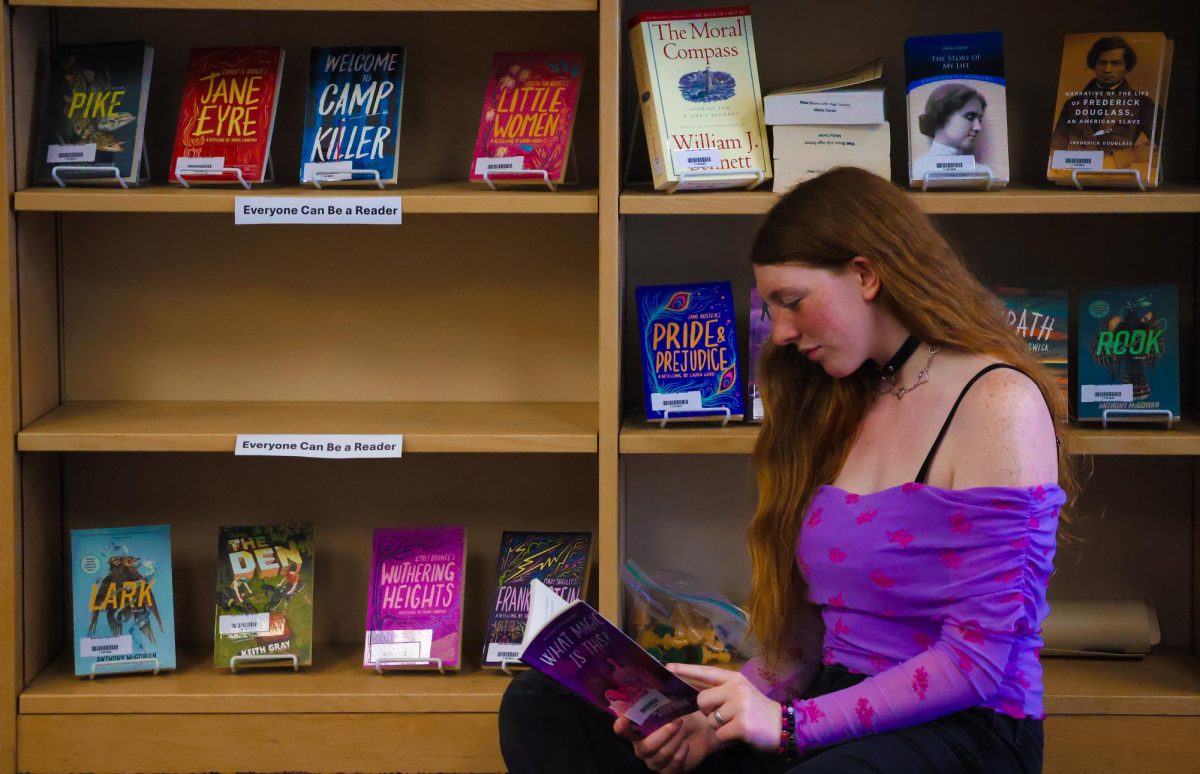 Sophomore Samantha Kervin reads one of the 14 dyslexic-friendly books she donated to the media center on Feb. 19.