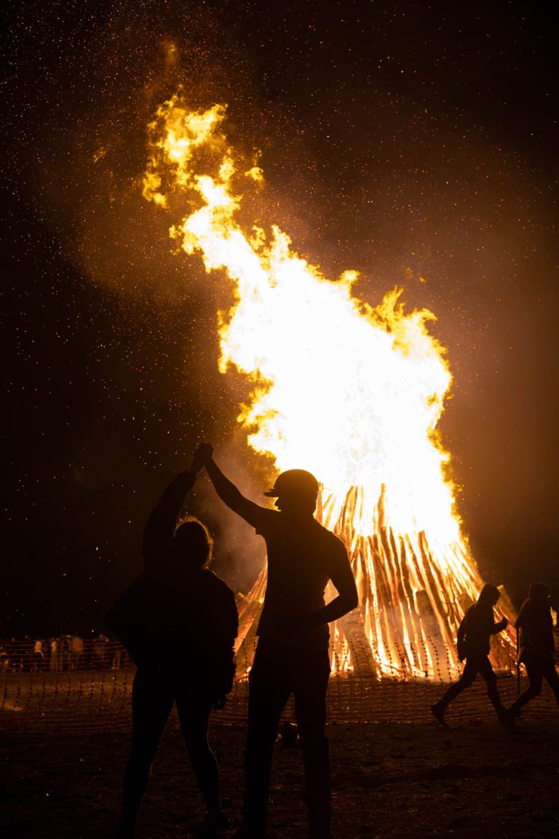 Corps member country dance in front of the stack at the Student Bonfire on Saturday, Jan. 25, 2025. (Micah Richter/The Battalion)