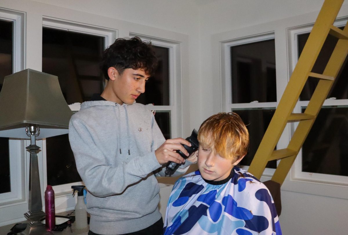 Student barber, sophomore Liam Baradaran cuts freshman Isaac Holden's hair.