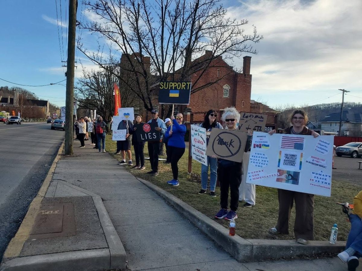 Activists line National Road, holding signs in protest of the current administration and advocating for a better future. Courtesy of Teddie Grogan. 