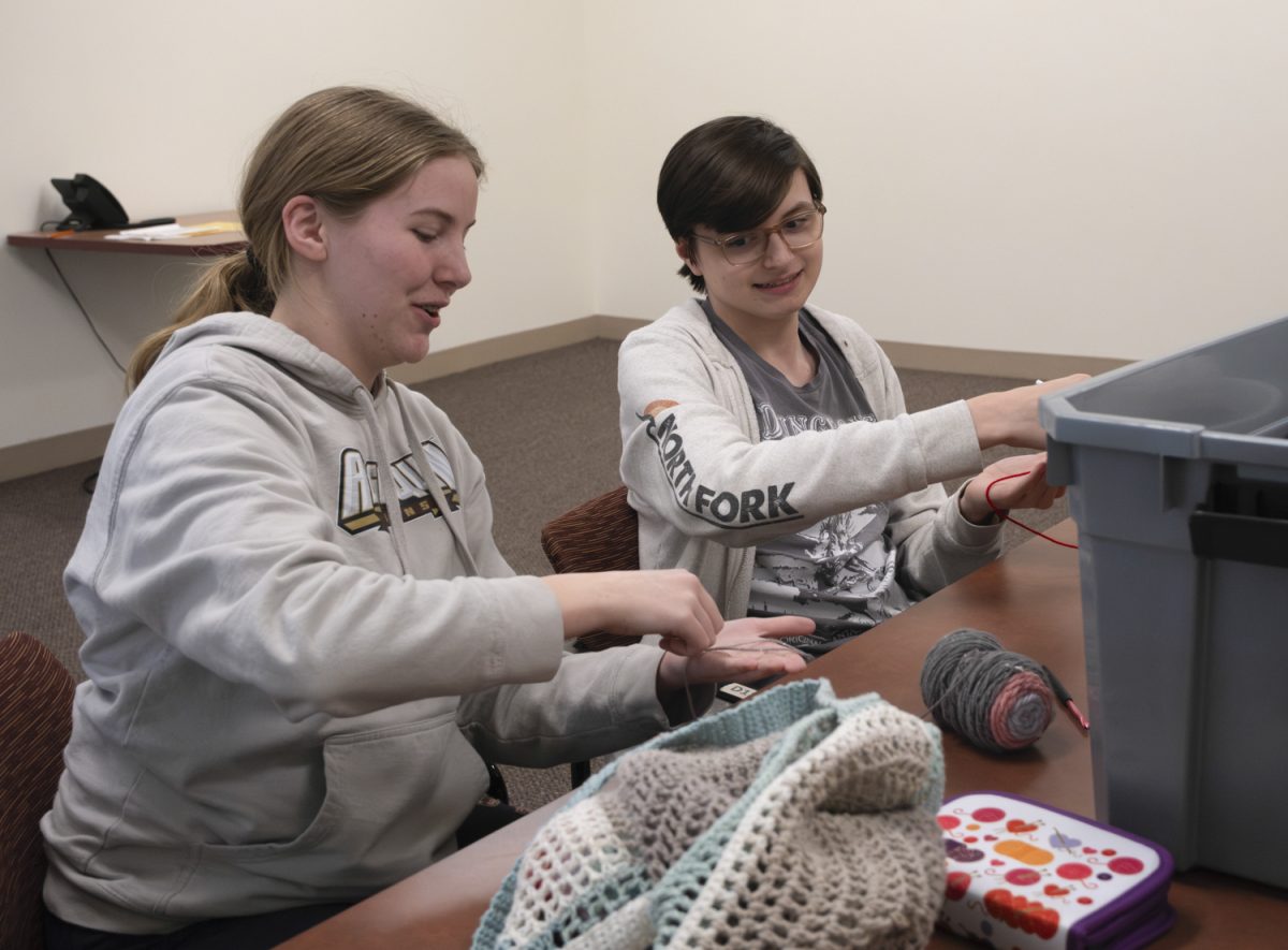 Sophomore Brianna Belanger shows sophomore Linq Kaelin how to start a chain during their weekly crochet club, hosted every Tuesday in the library.