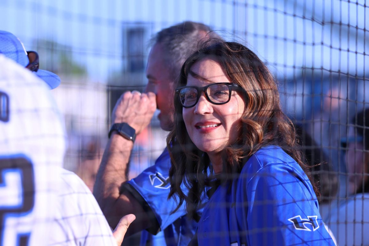 Food science teacher Lana Soukup stands with other parents of baseball players before the game against Flower Mound begins April 22. The team won the game 5-4.