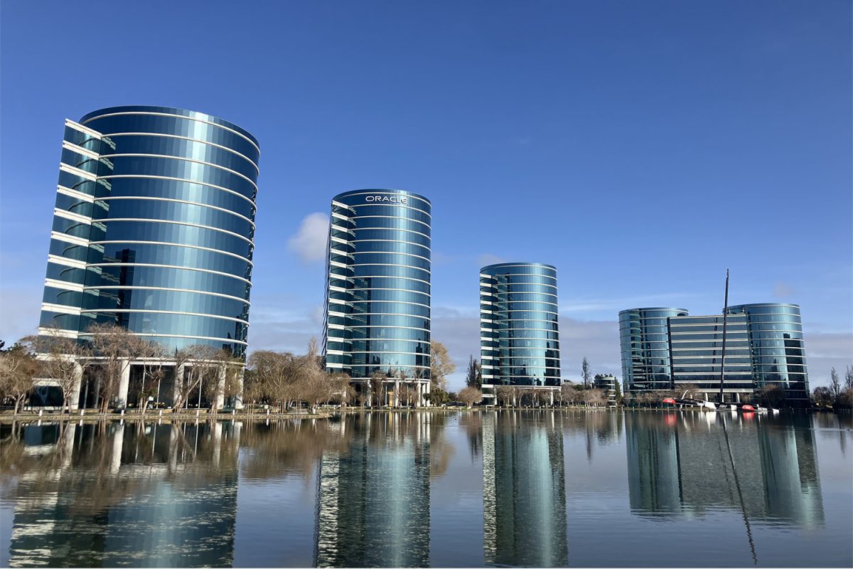 The buildings of Oracle Corporation in Redwood Shores stand imposingly against a blue sky. With 40% of the company’s total employees working at the Redwood Shores campus, it is a huge contributor to the Silicon Valley ecosystem, which is characterized by its competitiveness, fluidity, community, and inequality.