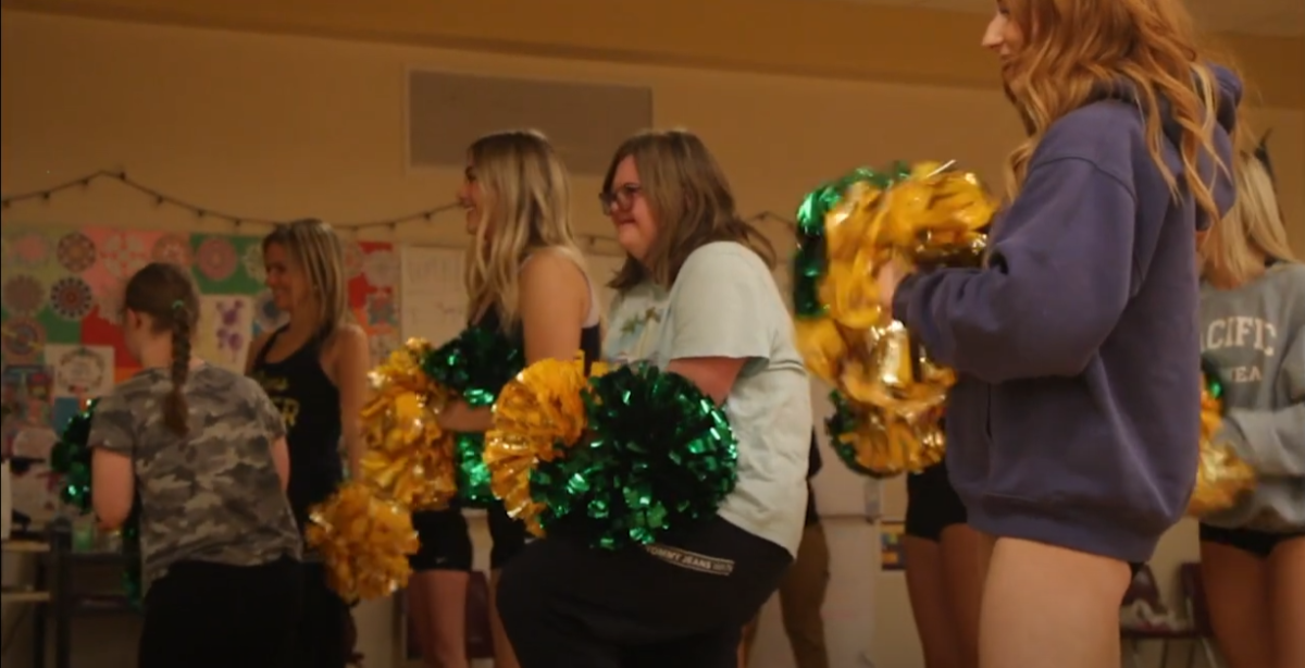 Sophie Maher, junior, practices with the cheer team in the dance room.