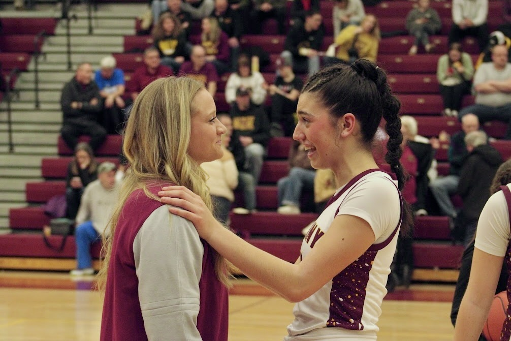 Codee Myers talks to senior Grace Buch during a break in play. Myers has coached for the girls’ basketball program since the 2021-22 season.