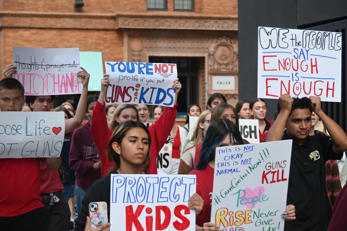 NO MORE. In order to call for policy change, on the walk to the Hennepin Country Government Center, students hold signs with various messages.