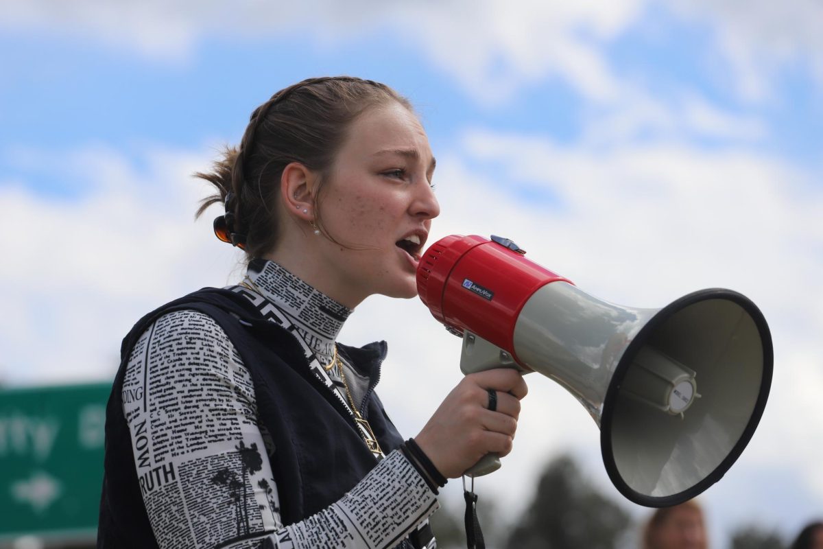 Senior Evelyn Seevers speaks to rallied students in the Staples parking lot as part of a statewide walkout against gun violence in schools. Seevers organized the protest for September 17, where over 400 students attended. During the walkout, Seevers spoke to the crowd of students, addressing gun violence statistics and rallying a collective voice. "It's time for us to use our voices together to bring the beginning of the end," Seevers said.