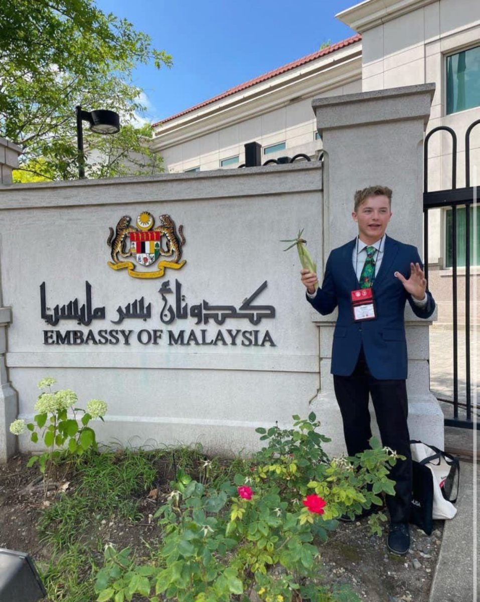 YES Abroad alumnus Isaac Vosburg stands outside the Malaysian Embassy in Washington D.C. with an ear of corn.