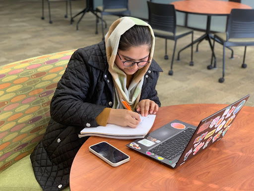 An international student studying in the Frank E. Gannett Memorial Library. Photo by a Tangerine staff member.