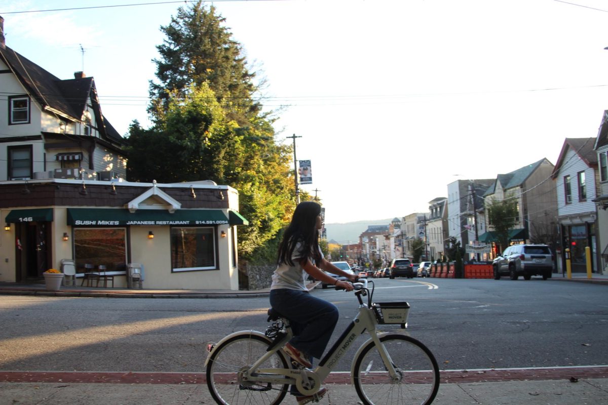 Ella Liu '27 rides a "Project MOVER" e-bike in downtown Dobbs Ferry. The transportation initiative was started originally in Ossining, and then moved to Dobbs Ferry this past summer. There are numerous "hubs" in the village, with one being in the intersection of the two busiest streets in town.