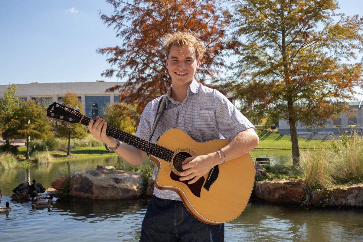 Industrial Distribution sophomore and contestant for The Voice, Aiden Ross poses and plays his guitar at Aggie Park on Sunday, Oct. 12, 2025. (Alessandra Balassa/The Battalion)