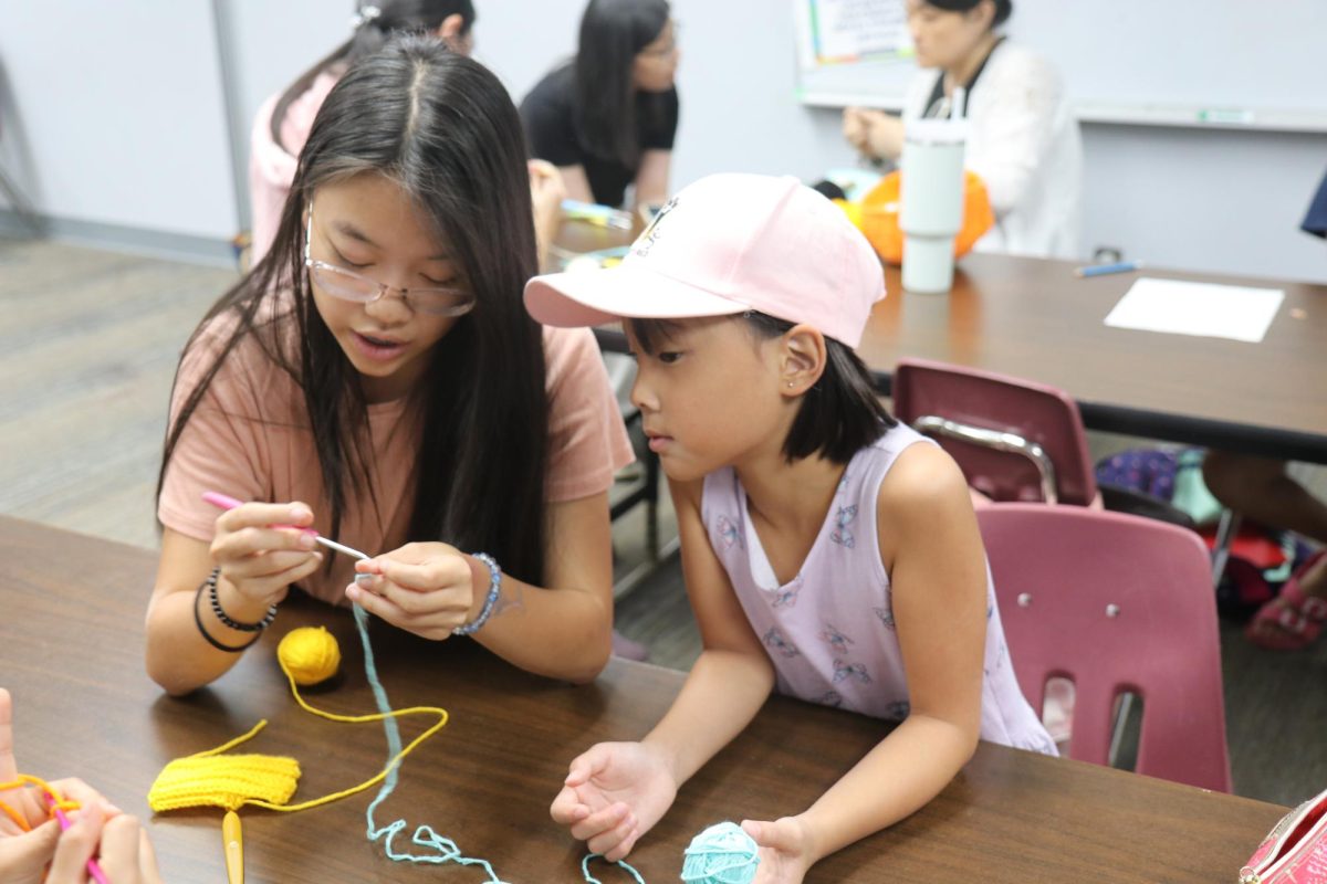 Amanda Moi, junior, instructs one of her students at a CReT class on Sunday, Sept. 28. Moi advises the students with the jellyfish pattern as her student observes up close. Moi joined CReT during her freshman year.