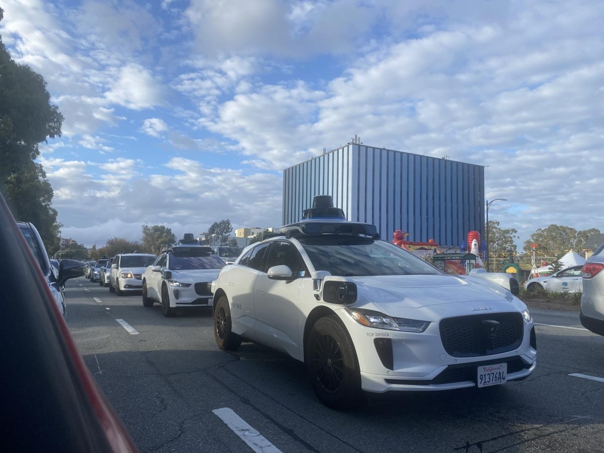 Two Waymo taxis drive down El Camino Real, part of the area included in the company’s most recent expansion in June.