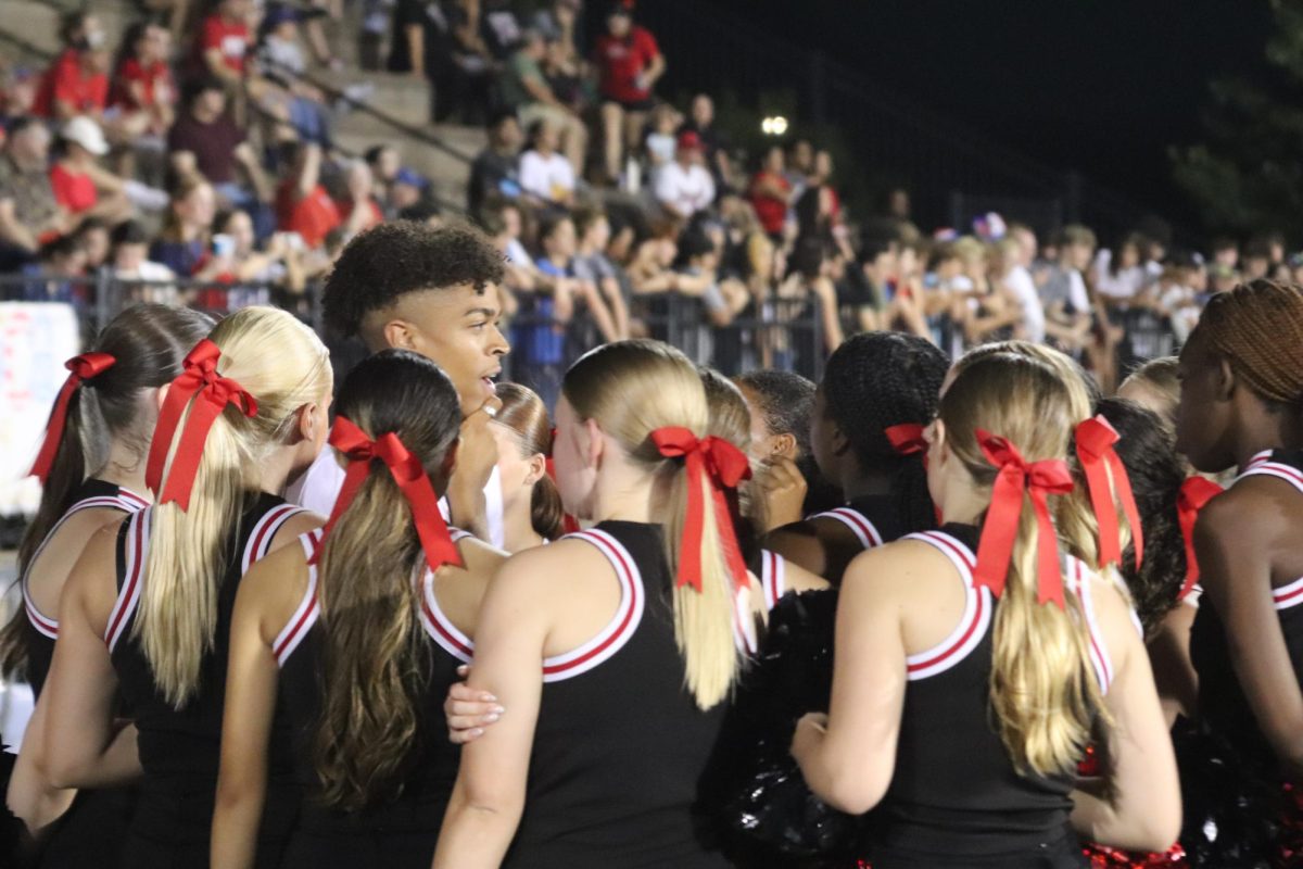 On the sidelines, Phillips-Worrell gathers the team at the Sept. 12 football game against Junction City. 