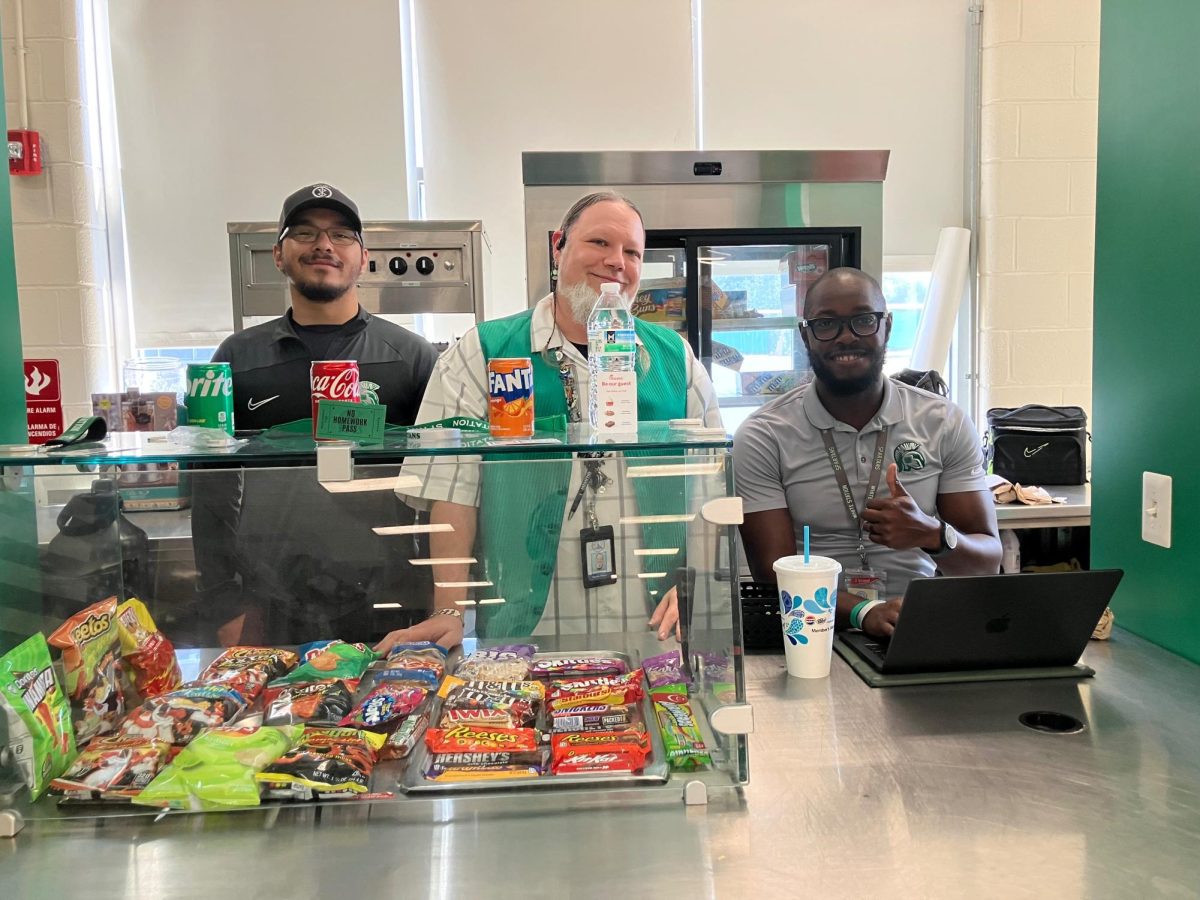 Left to Right: Coach Rye, Mr. Pepper, and Coach KG are shown working at the Spartan Store. The store is open on Fridays.