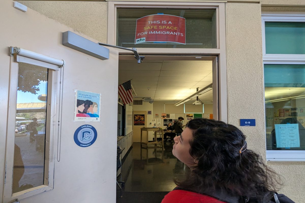 Itza Perez views a sign that has a supportive message for immigrants. Signs like this can offer hope to immigrant communities in times of instability. “I’m not an immigrant. My parents aren’t immigrants. We’re okay. But for some extended family, it’s not the same. It’s definitely very scary,” Perez said.