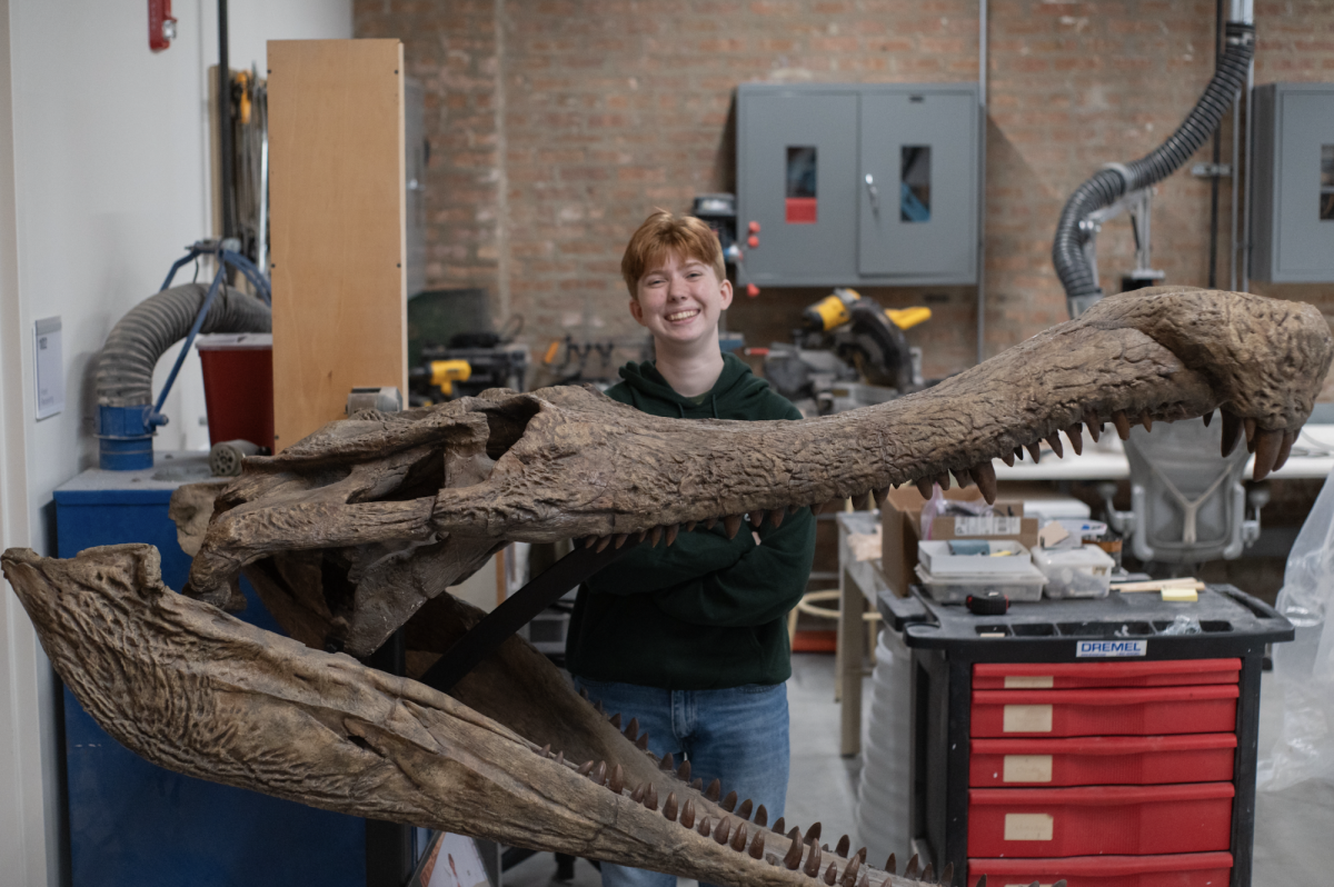 Senior Catherine Groves poses with a massive skull. Most people don't discover their career until college, but some teens are already getting hands-on experience with paleontology through the University of Chicago’s Fossil Lab.