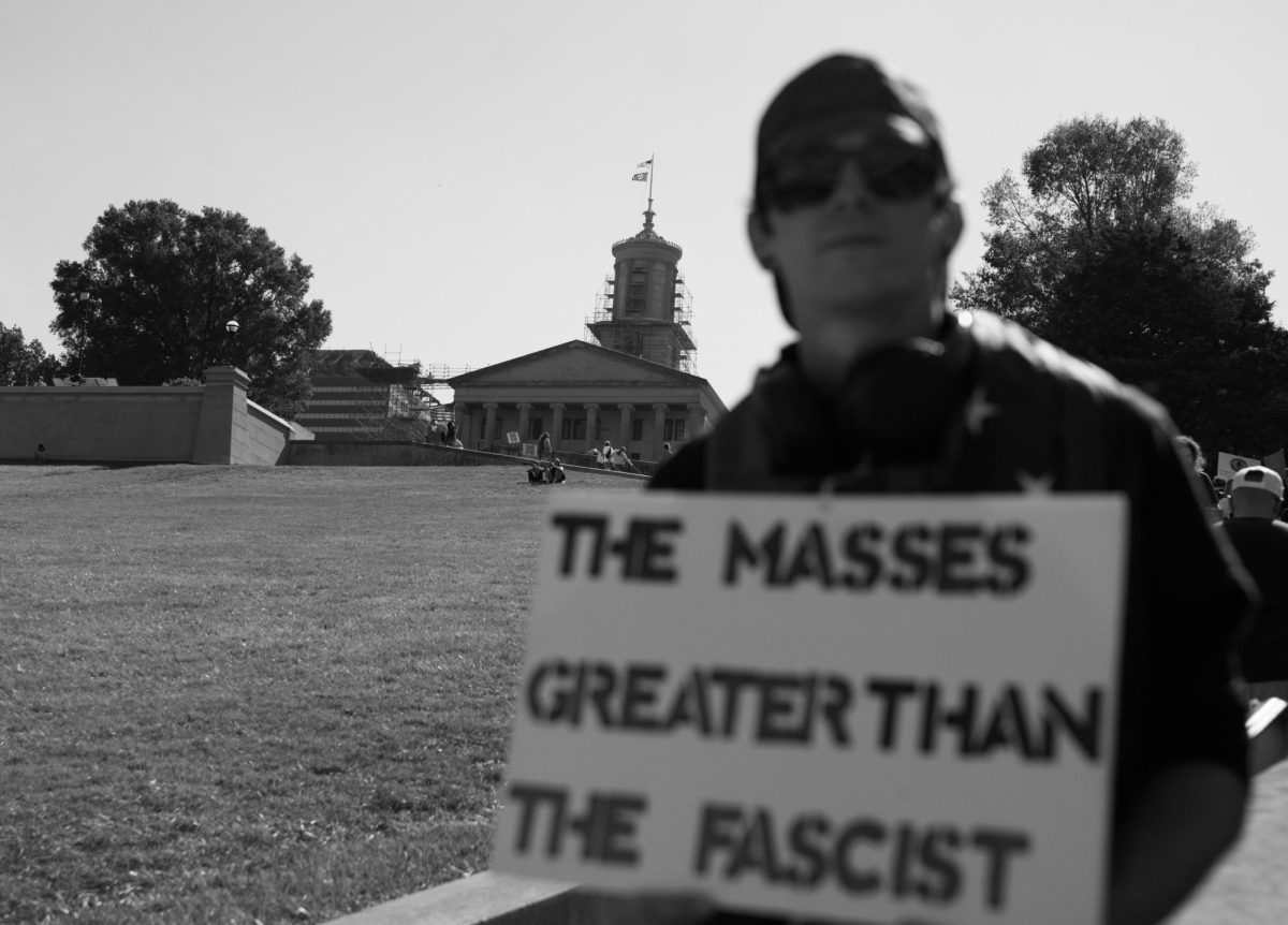 A demonstrator holds a sign that reads "THE MASSES GREATER THAN THE FASCIST" with the Tennessee State Capitol in the background, as photographed on Oct. 18, 2025. (Hustler Multimedia/George Albu)
