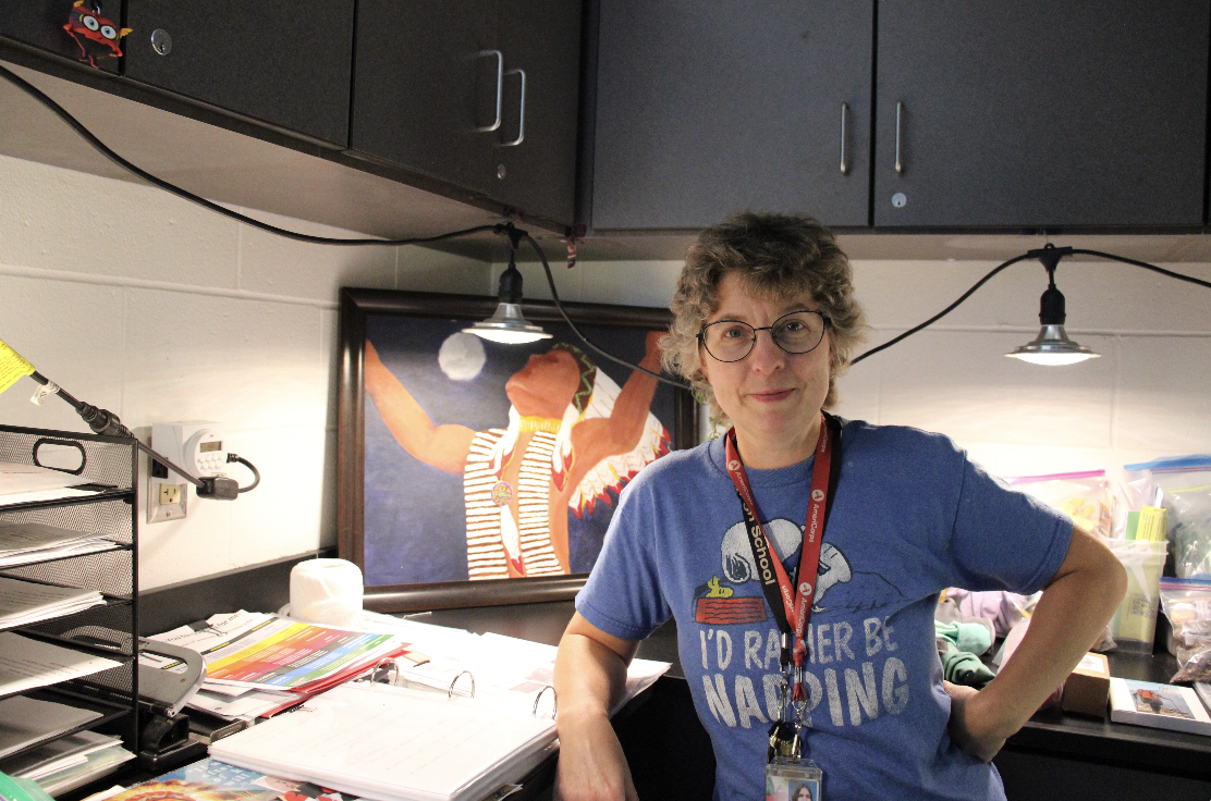 Science teacher Abby Taylor in her classroom, in front of a Native American painting that she painted in seventh grade.