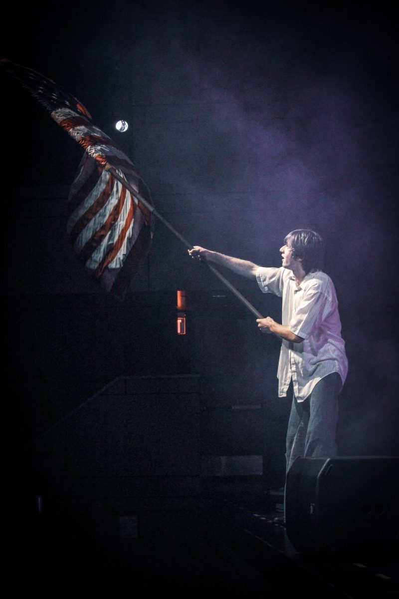 Junior Teddy Schaeffer waves the American Flag during the performance. 