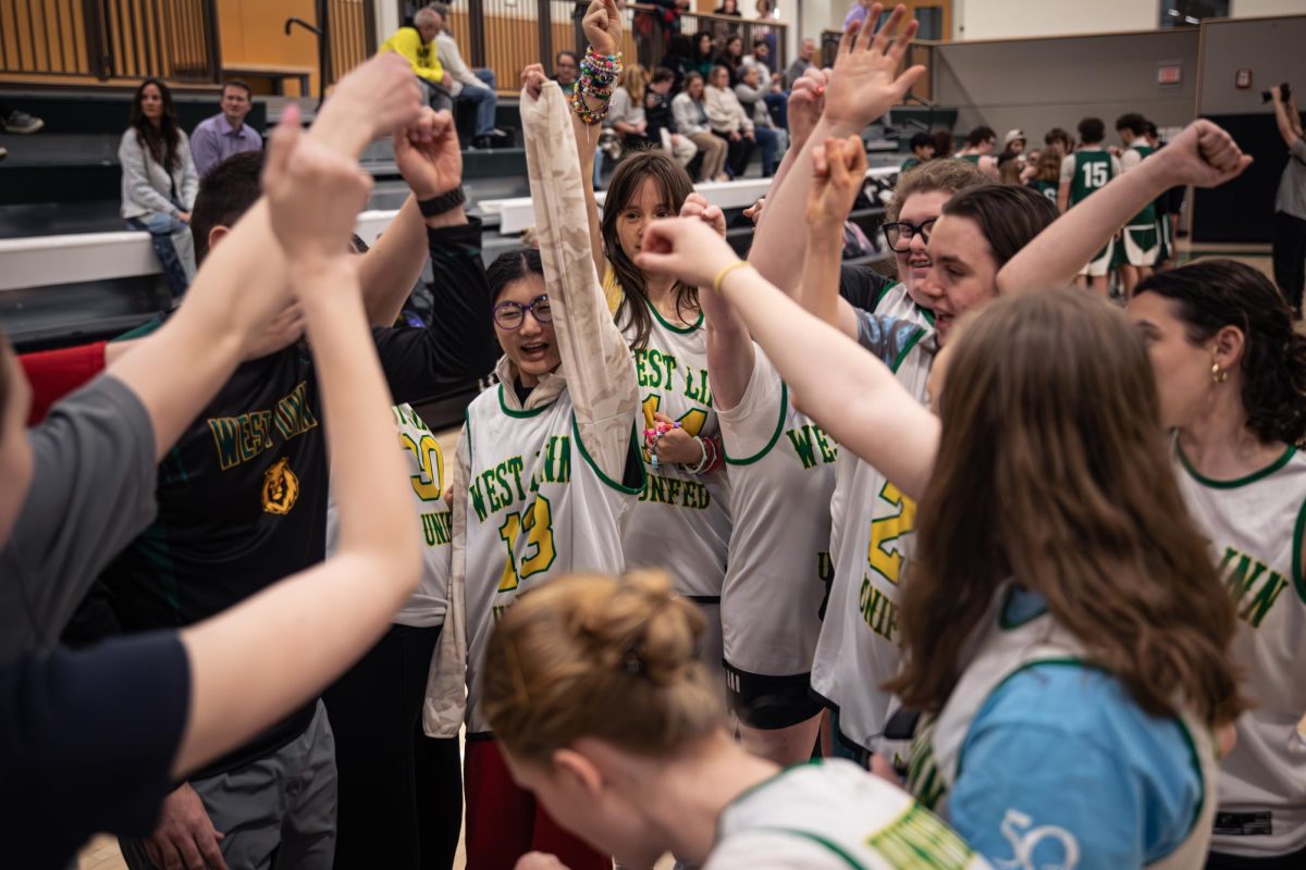 ’Lions on three.’ Neal Glynn, health and Unified teacher and Unified basketball coach, leads a pregame huddle with the athletes. When it comes to coaching the team, Glynn has three main goals: “Lots of smiles, lots of hugs, and having a good time,” Glynn said.